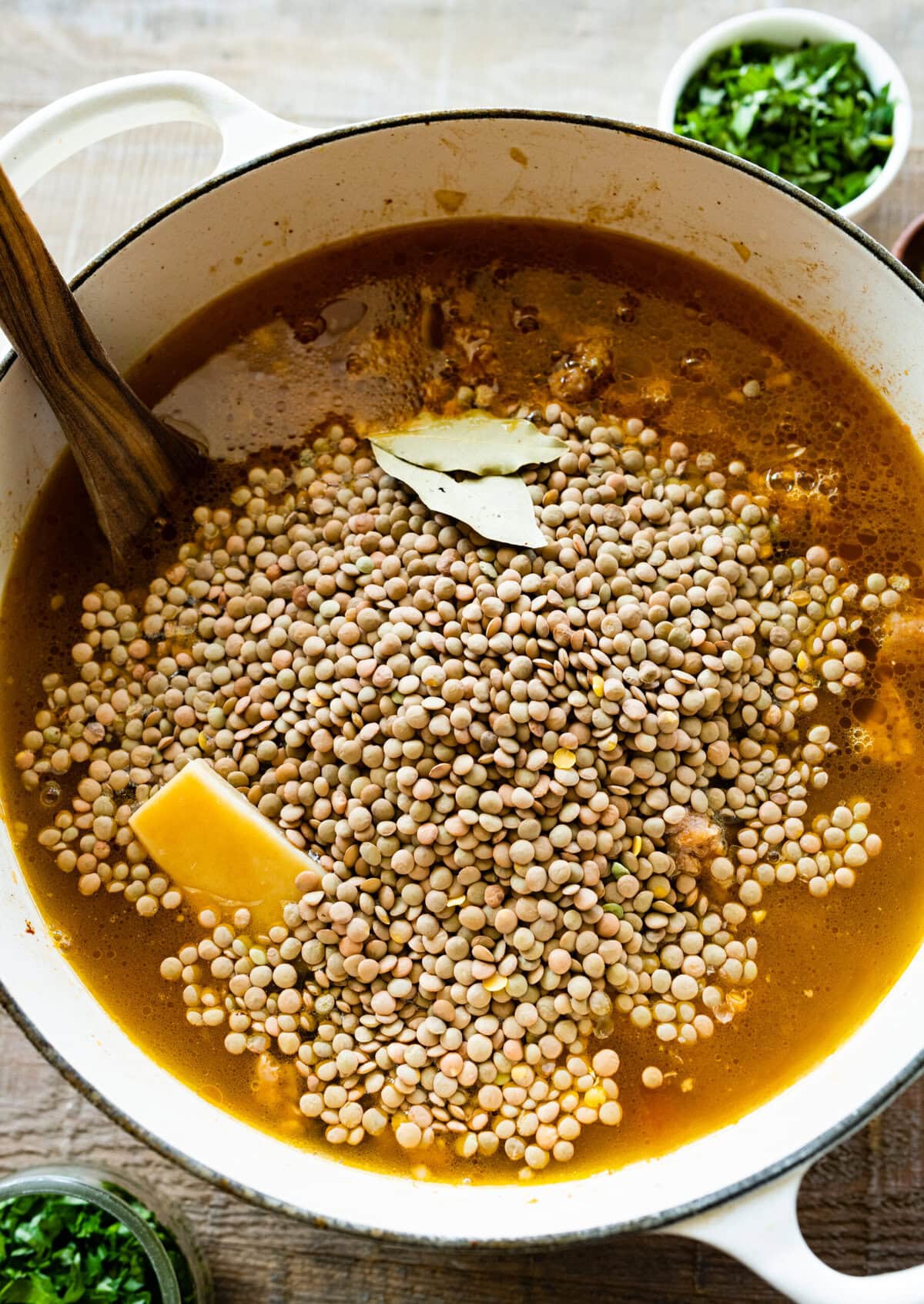 How to make sausage lentil soup (Italian recipe) step-by-step: add lentils, bay leaf and parmigiano rind.