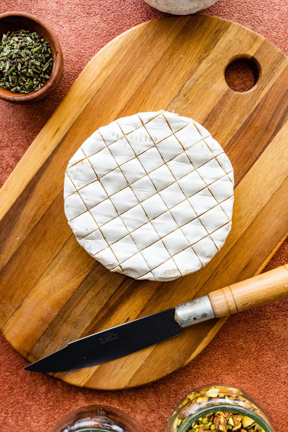 How to make baked brie recipe step-by-step instructions: score the top of the brie with a knife.