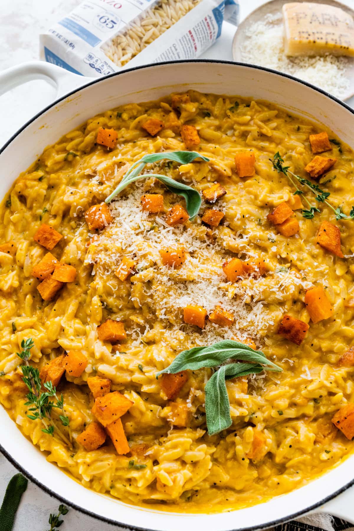 finished butternut squash orzo recipe dish in the pot with sage on top.