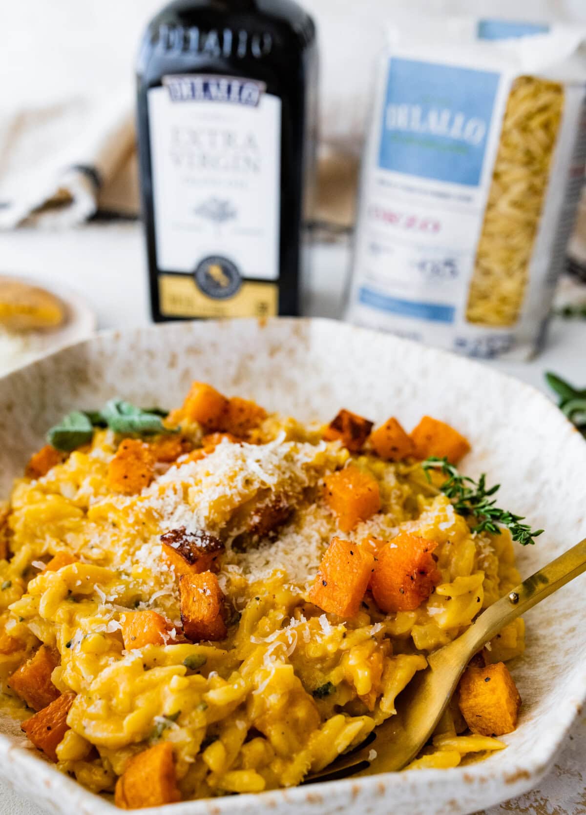 Bowl of the finished butternut squash orzo with a fork ready to eat.