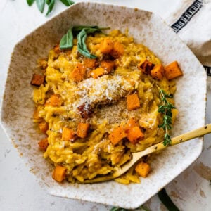 Bowl of the finished butternut squash orzo with a fork ready to eat.