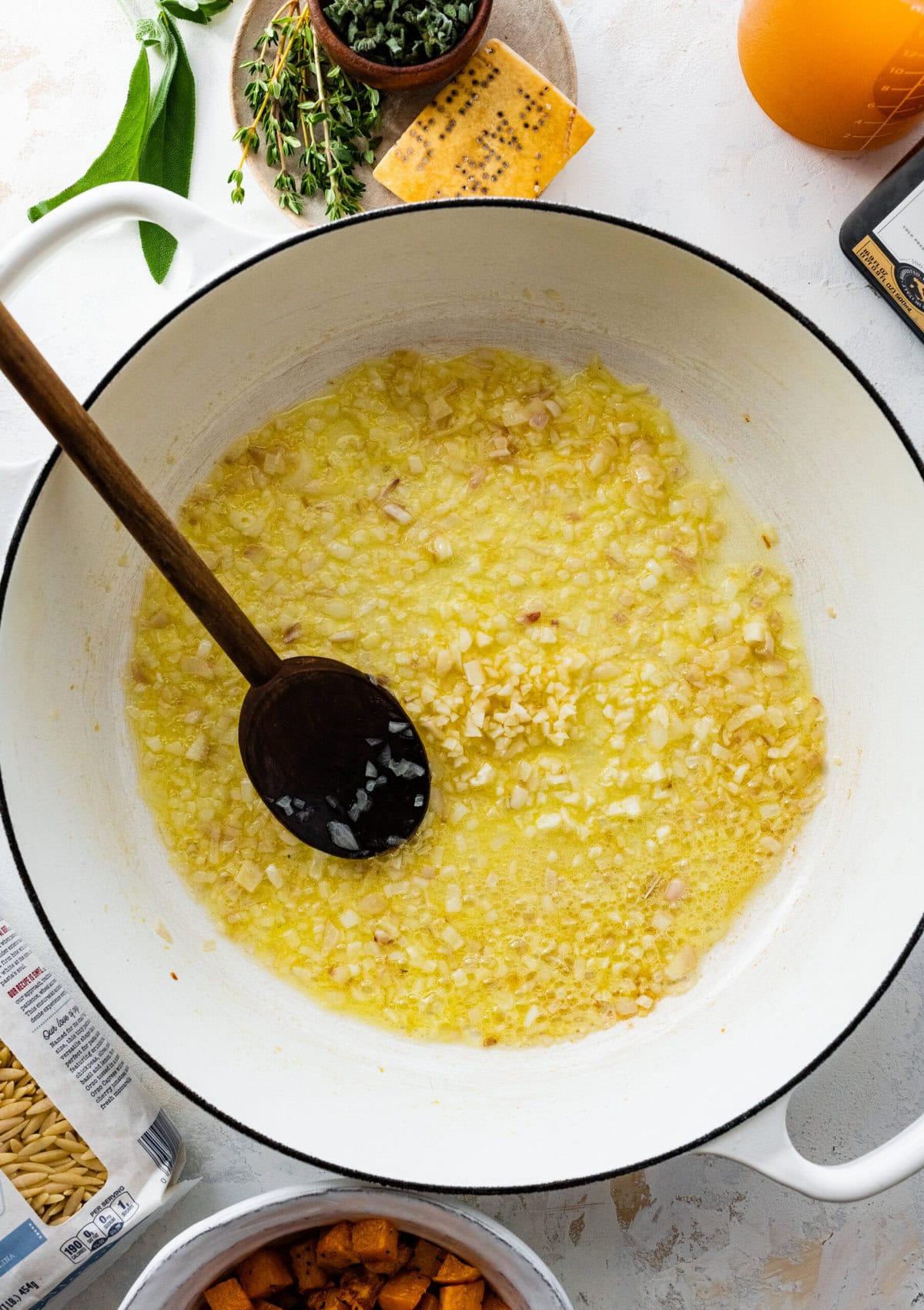 How to make Butternut Squash Orzo Recipe Step-by-step: saute the shallot and garlic in olive oil in a pot.