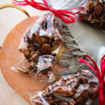 Candied pecan in a clear bag with red ribbon tied around the top to give as a gift.