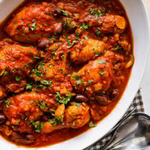 cooked chicken cacciatore recipe in a platter with fresh parsley on top.