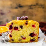 Cut loaf of cranberry orange bread on parchment paper.