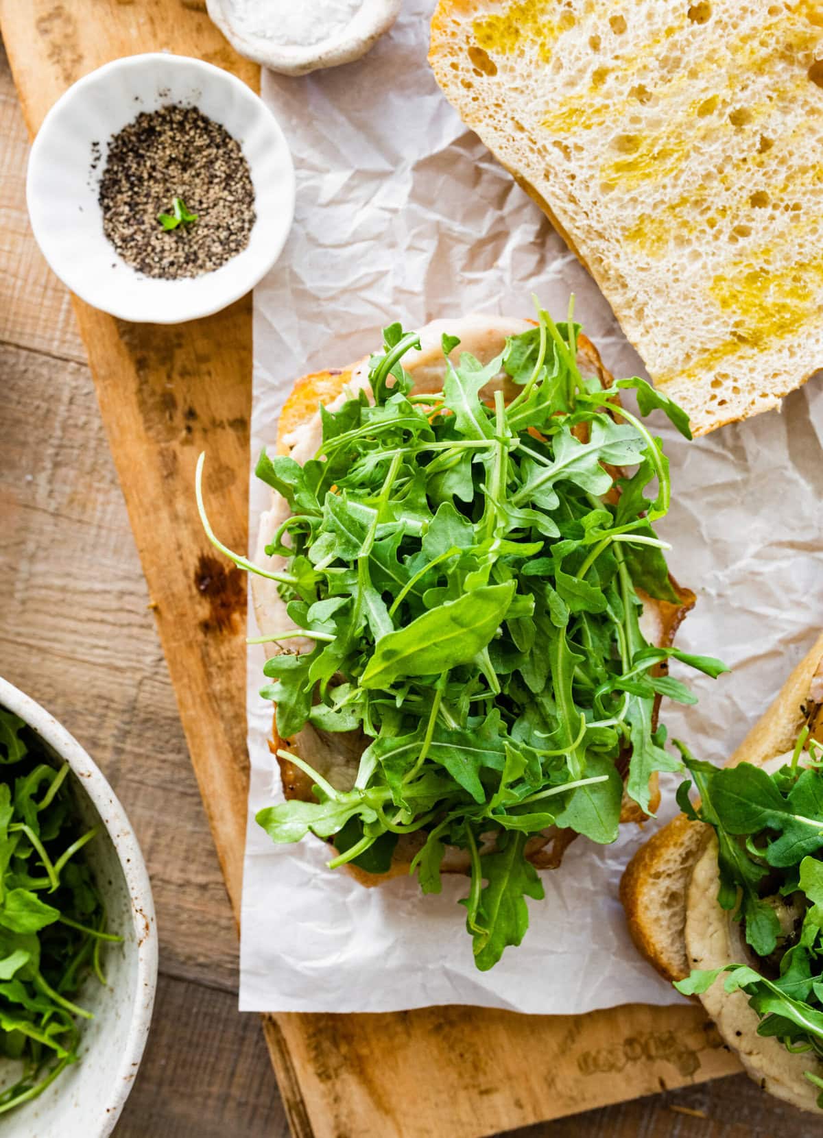 how to make porchetta sandwich recipe. Add the leftover and warmed porchetta to the ciabatta bread. Add the arugula on top of the porchetta.