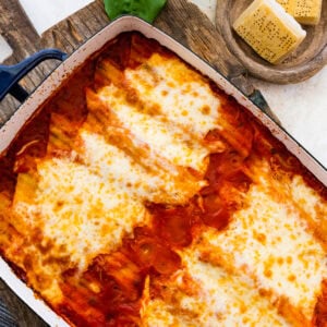 Baked Spinach and ricotta manicotti in a beautiful casserole dish. Fresh parmigiano cheese on the side.