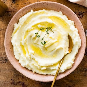 Serve the mashed potatoes in a serving plate with a little butter on top and sprig of thyme, if desired. Close up of the mashed potatoes dish.