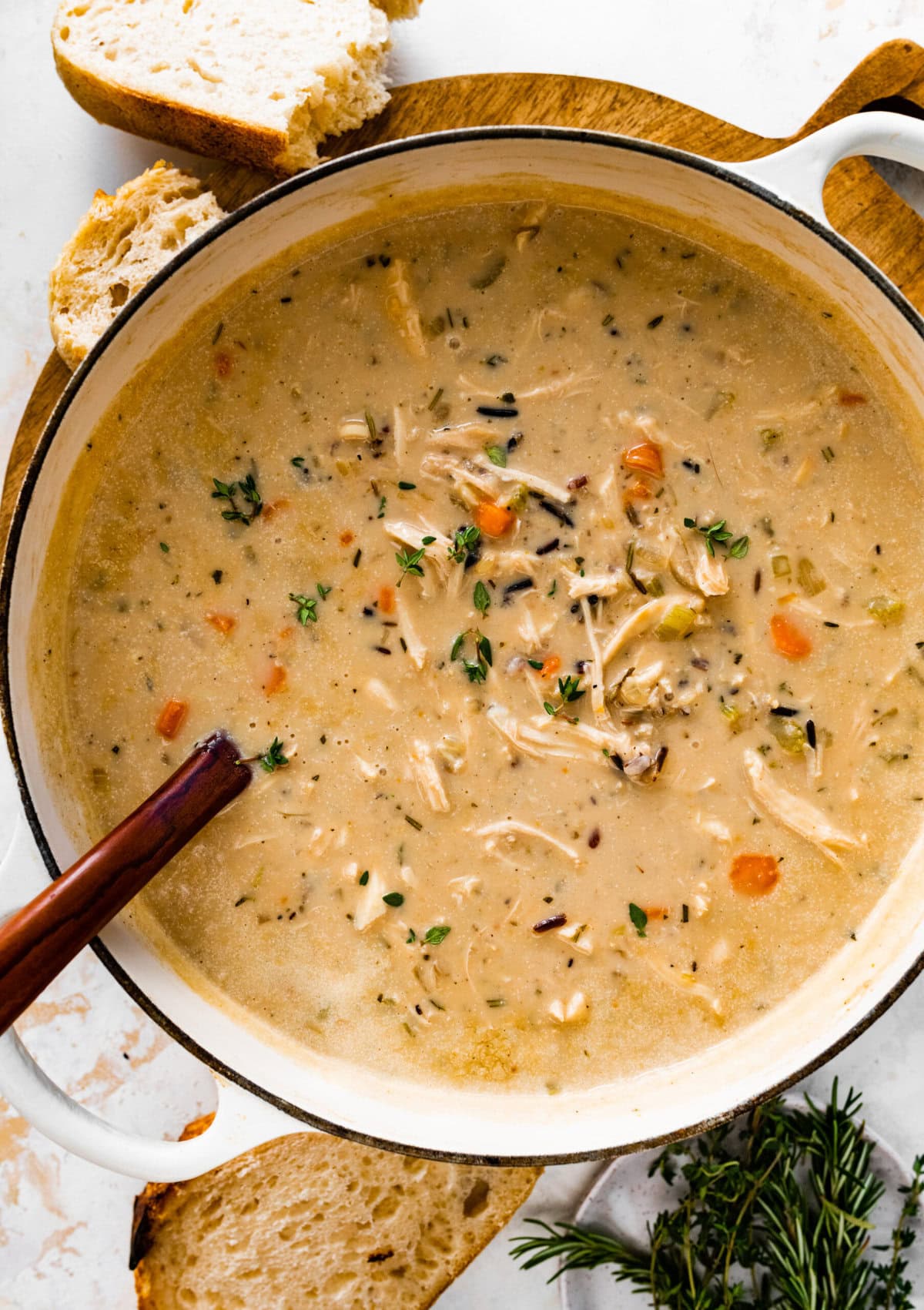 Creamy Chicken Wild Rice Soup Recipe in a soup pot with a wooden ladle in it.
