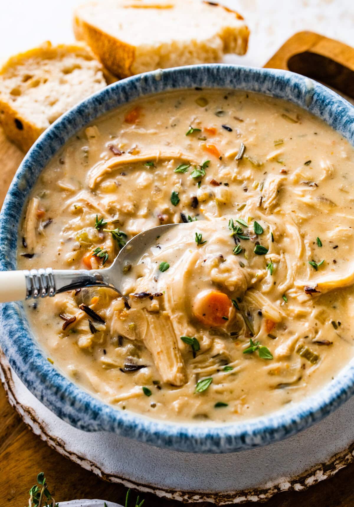 Spoon scooping from a bowl of Creamy Chicken Wild Rice Soup.