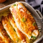 Spatula lifting out one of the white chicken enchiladas to serve.