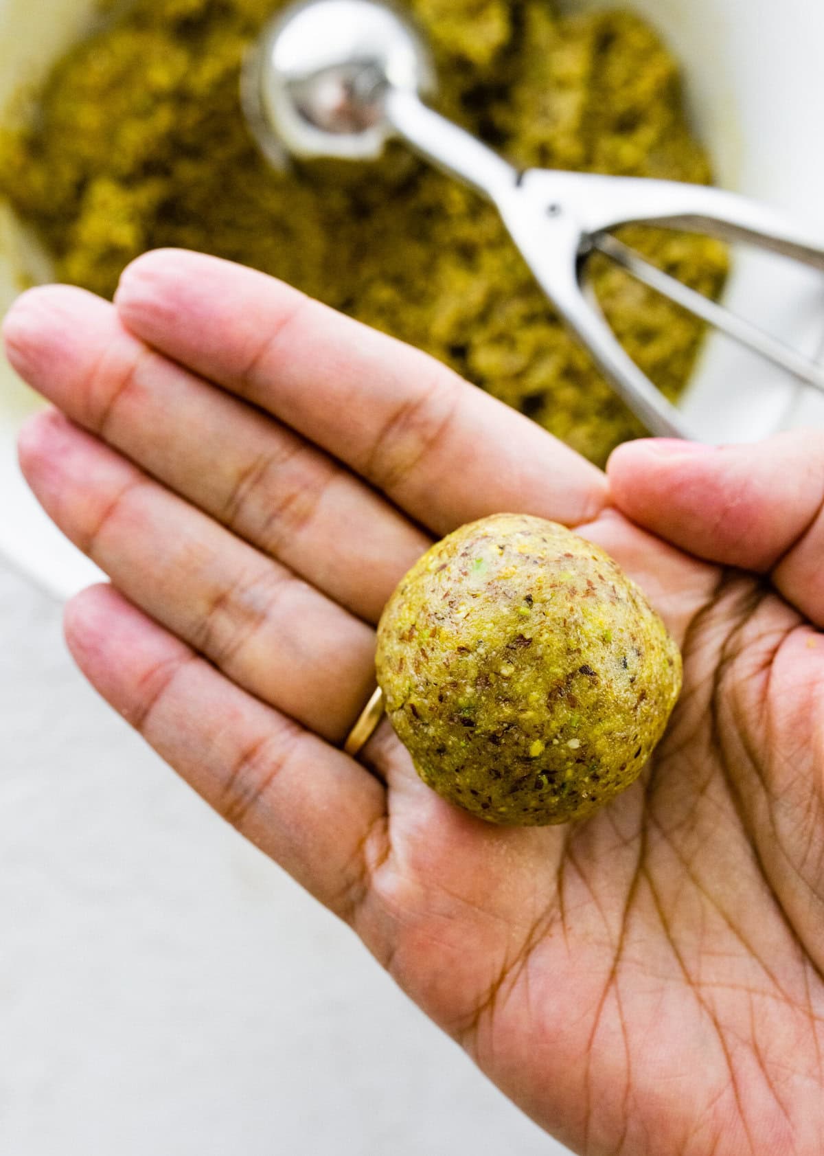 Making Italian Pistachio Cookies- a little ball of cookie dough held in a hand.
