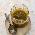 Zesty Italian Dressing in a glass jar with a spoon.
