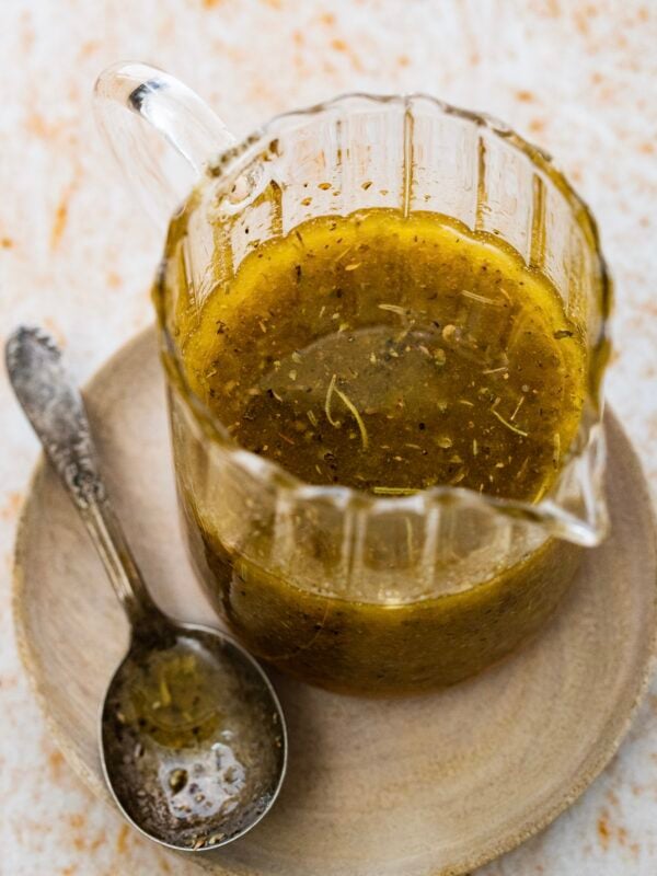 Zesty Italian Dressing in a glass jar with a spoon.