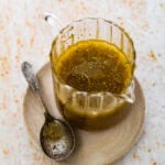 Zesty Italian Dressing in a glass jar with a spoon.