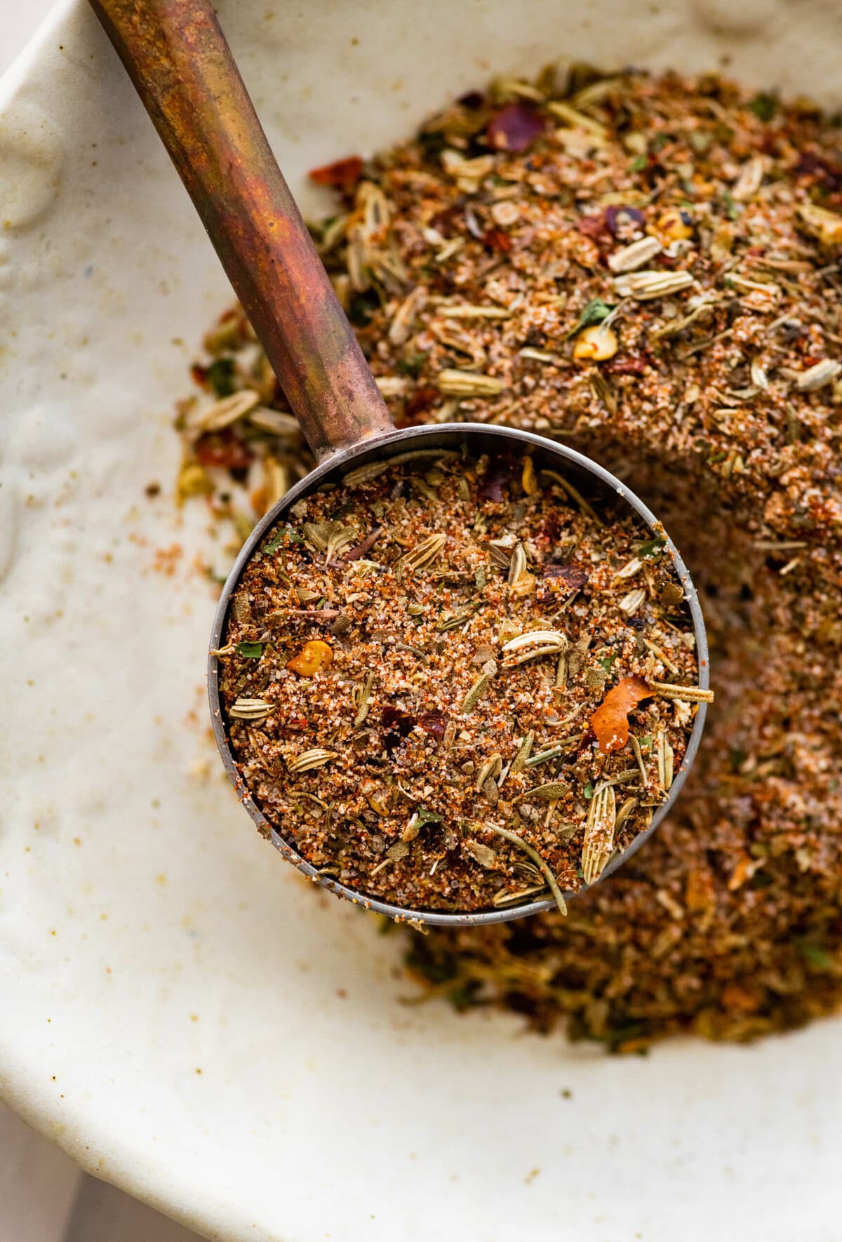 close up of a teaspoon with Italian sausage seasoning in it. 