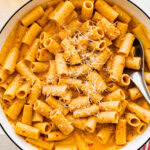 Nduja pasta sauce and pasta in a serving dish with a spoon.