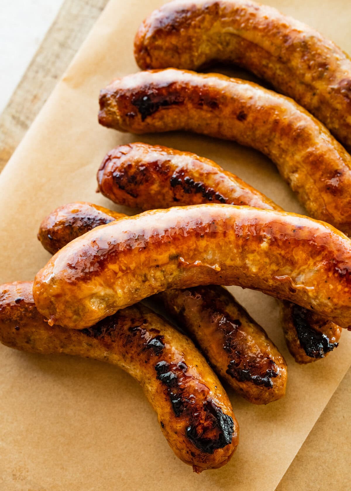 Italian sausages on parchment paper and wood board.