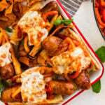 All the Italian sausage sandwiches on a platter with basil on the side.