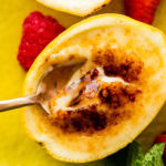a bite with the spoon of the creamy lemon posset and brulee topping.