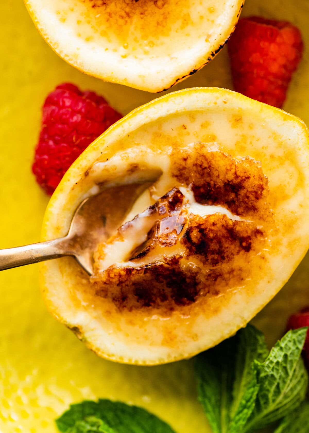 a bite with the spoon of the creamy lemon posset and brulee topping.