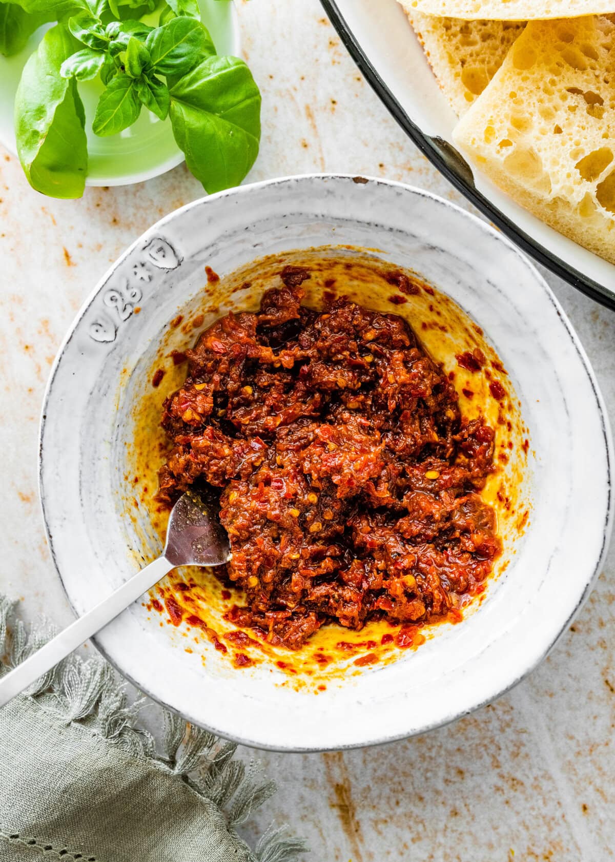 Nduja paste in a white bowl with a spoon.