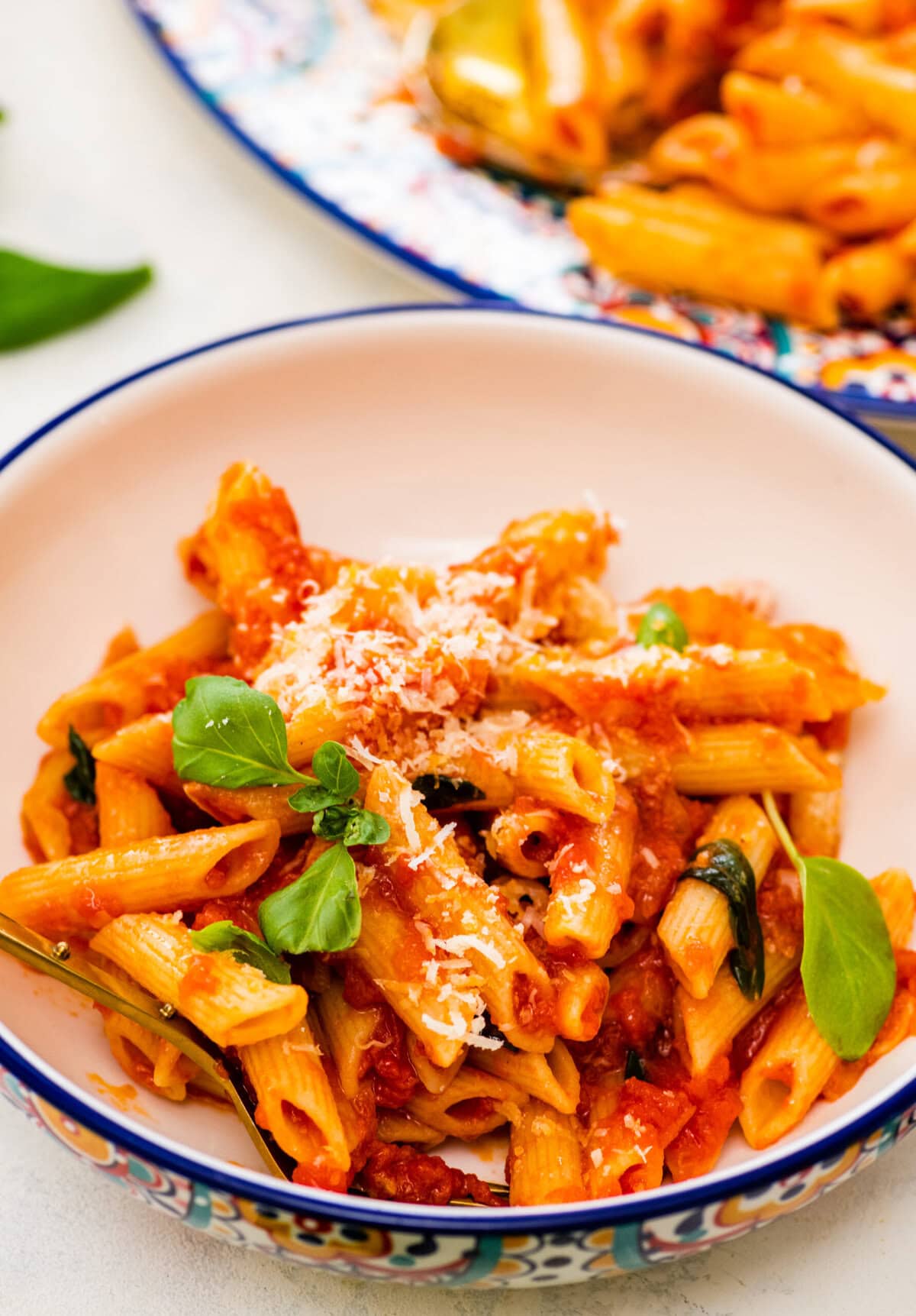penne pomodoro in a blue and white bowl with a fork in it.