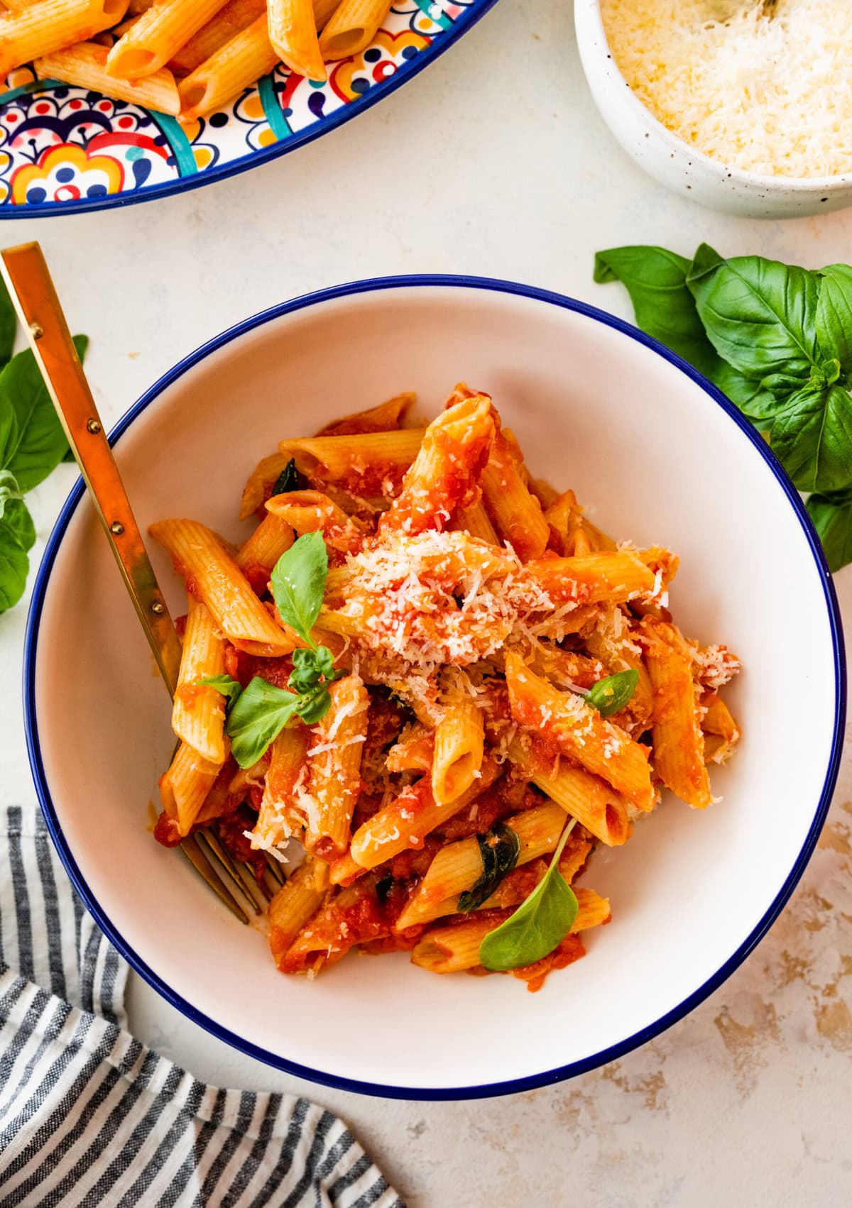 penne pomodoro in a blue and white bowl with a fork in it.