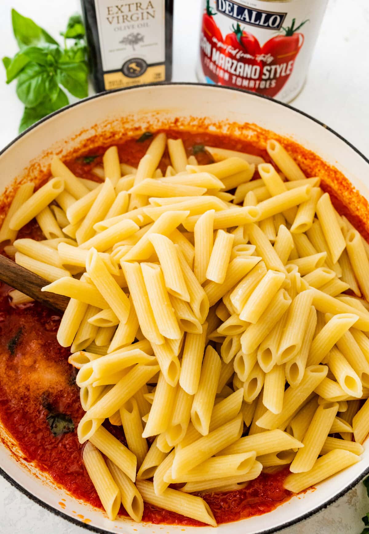 perfectly cooked penned pasta added in the pan with pomodoro sauce.
