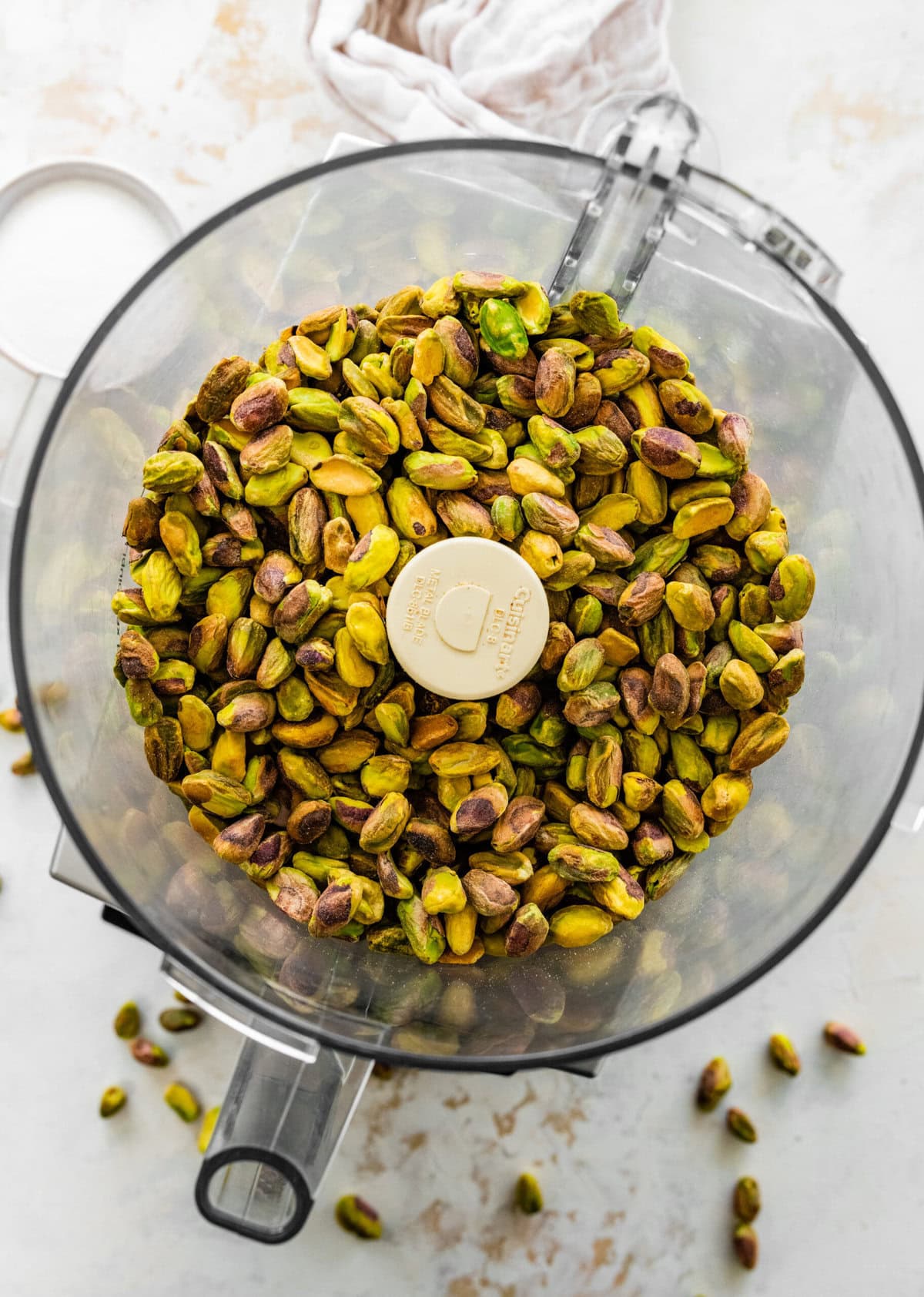 pistachios in a food processor ready to mix.