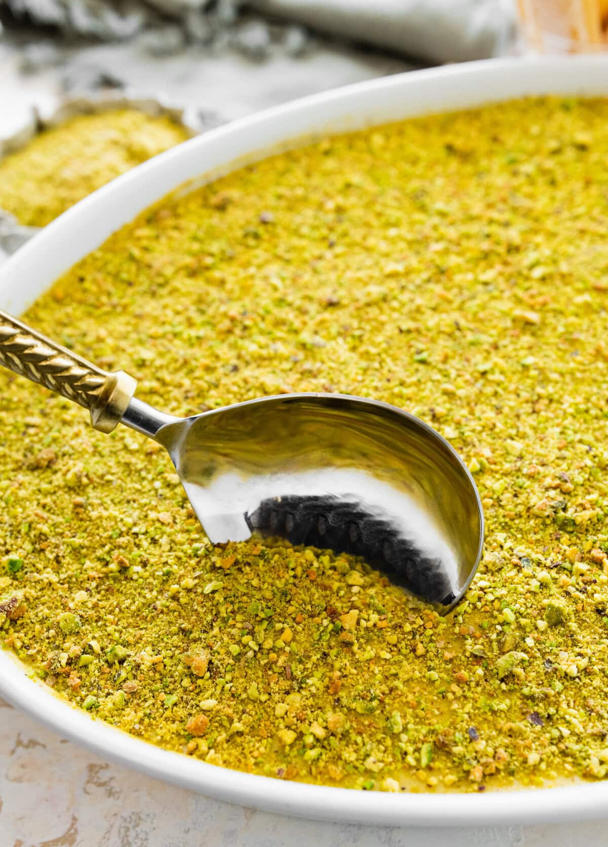 spoon taking out a portion of the pistachio tiramisu recipe.