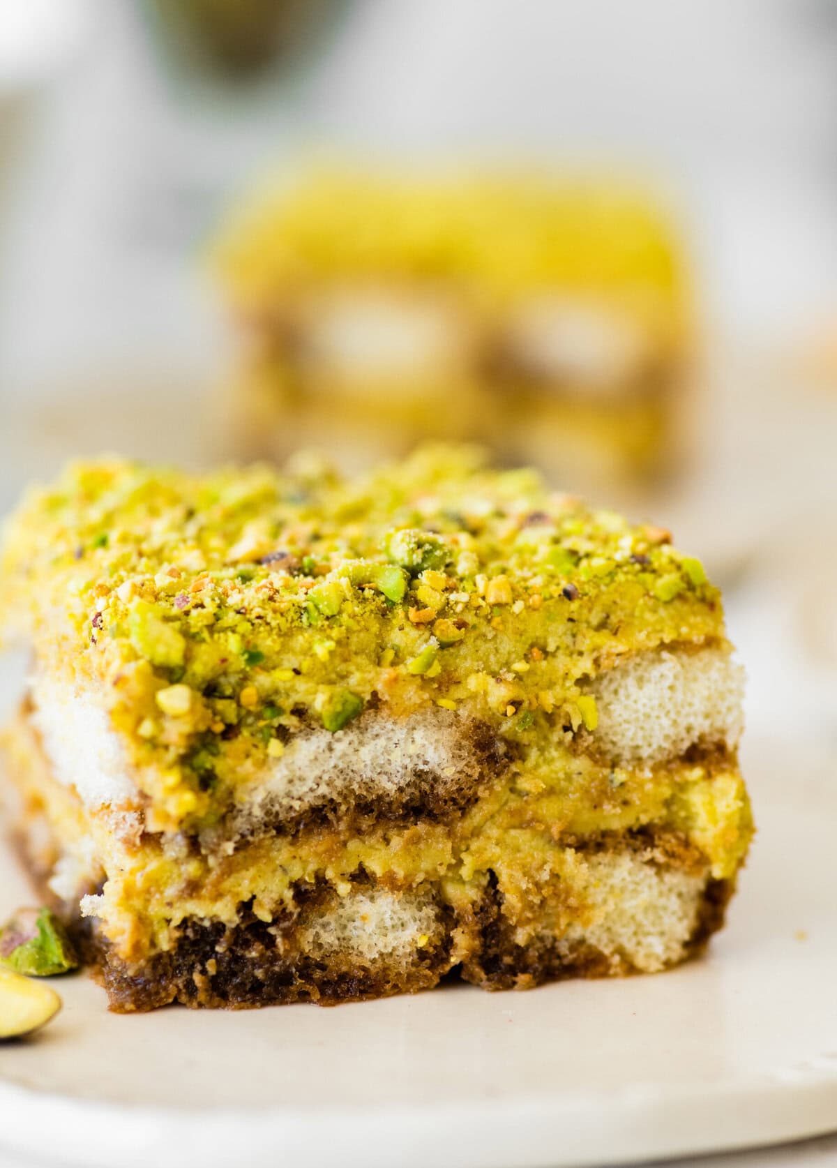 slice of pistachio tiramisu on a plate showing the layers.