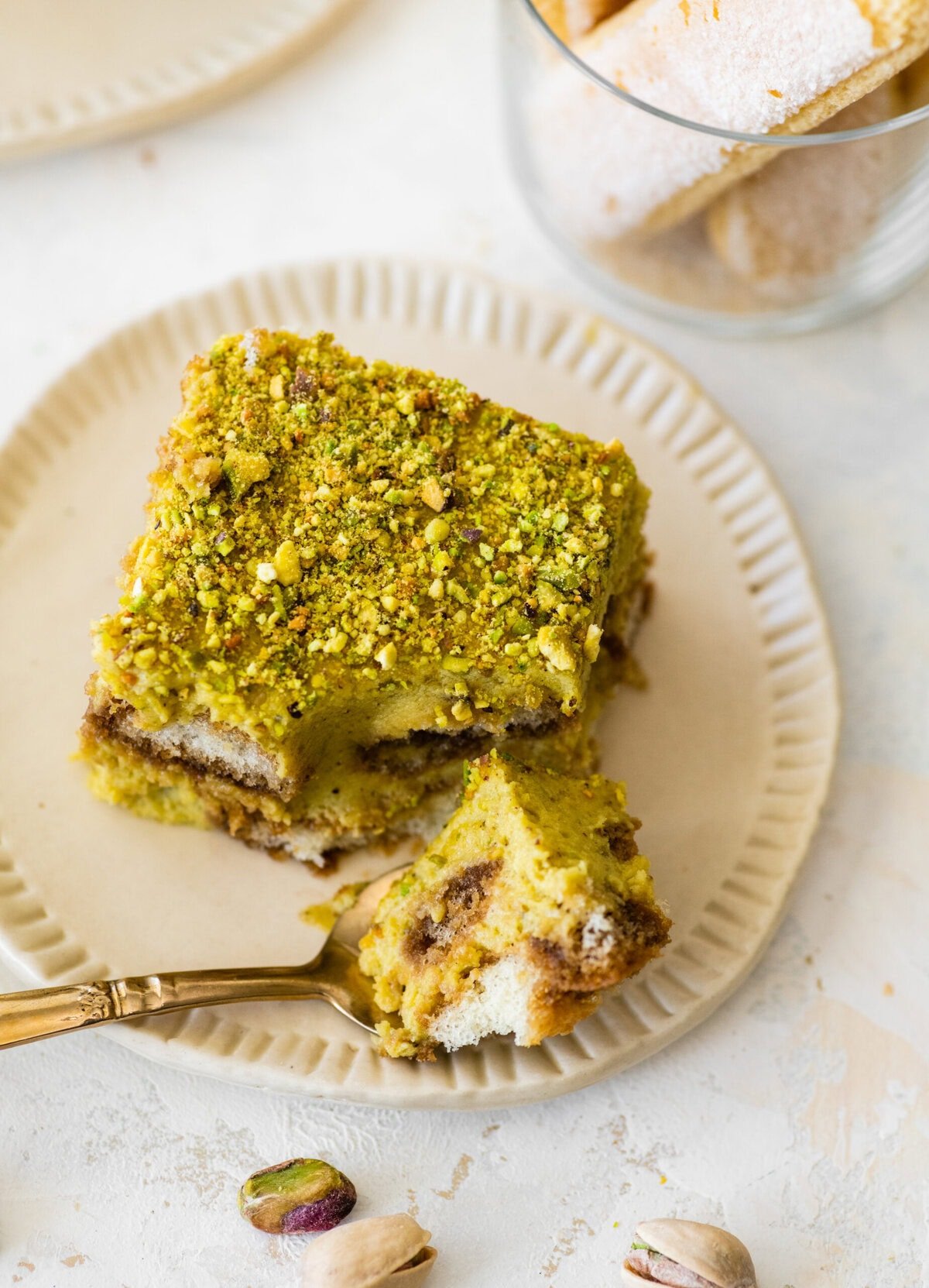 bite taken out of the pistachio tiramisu slice.
