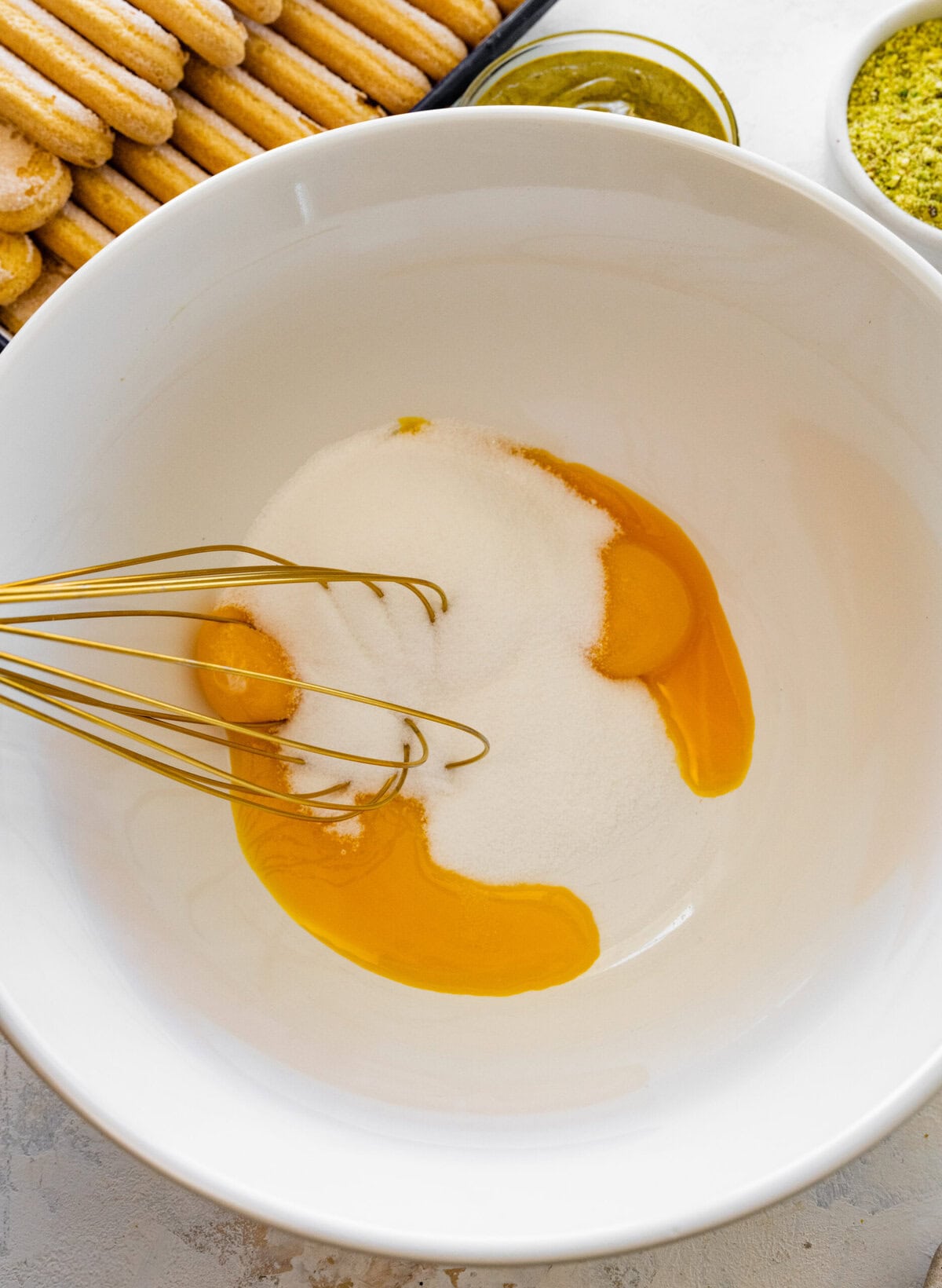 sugar and eggs in a bowl with a whisk.