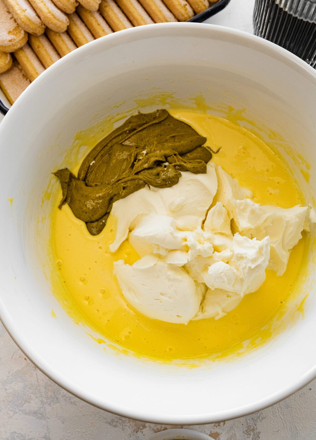 egg yolk mixture with mascarpone and homemade pistachio cream in bowl.