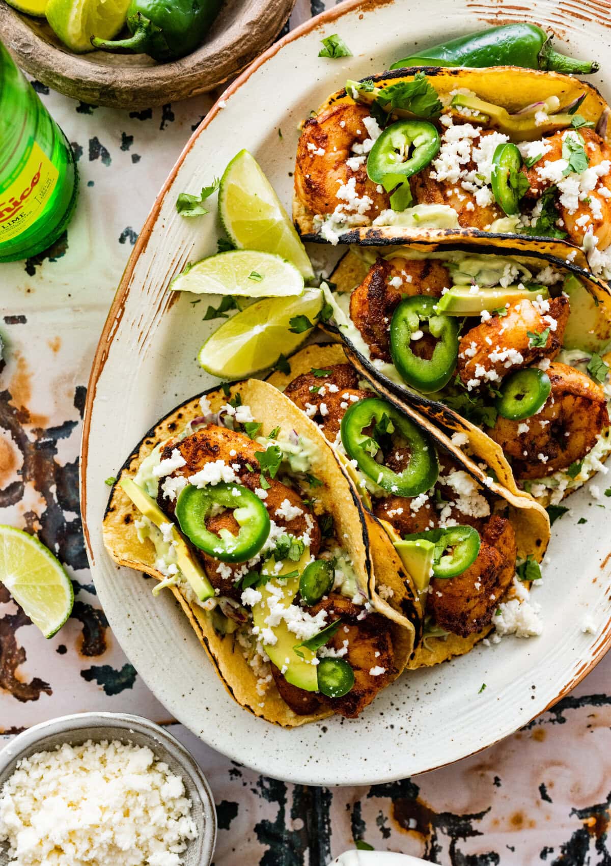 assembled shrimp tacos with creamy slaw and all the toppings including limes.