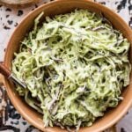 creamy avocado slaw in a bowl with a spoon in it.