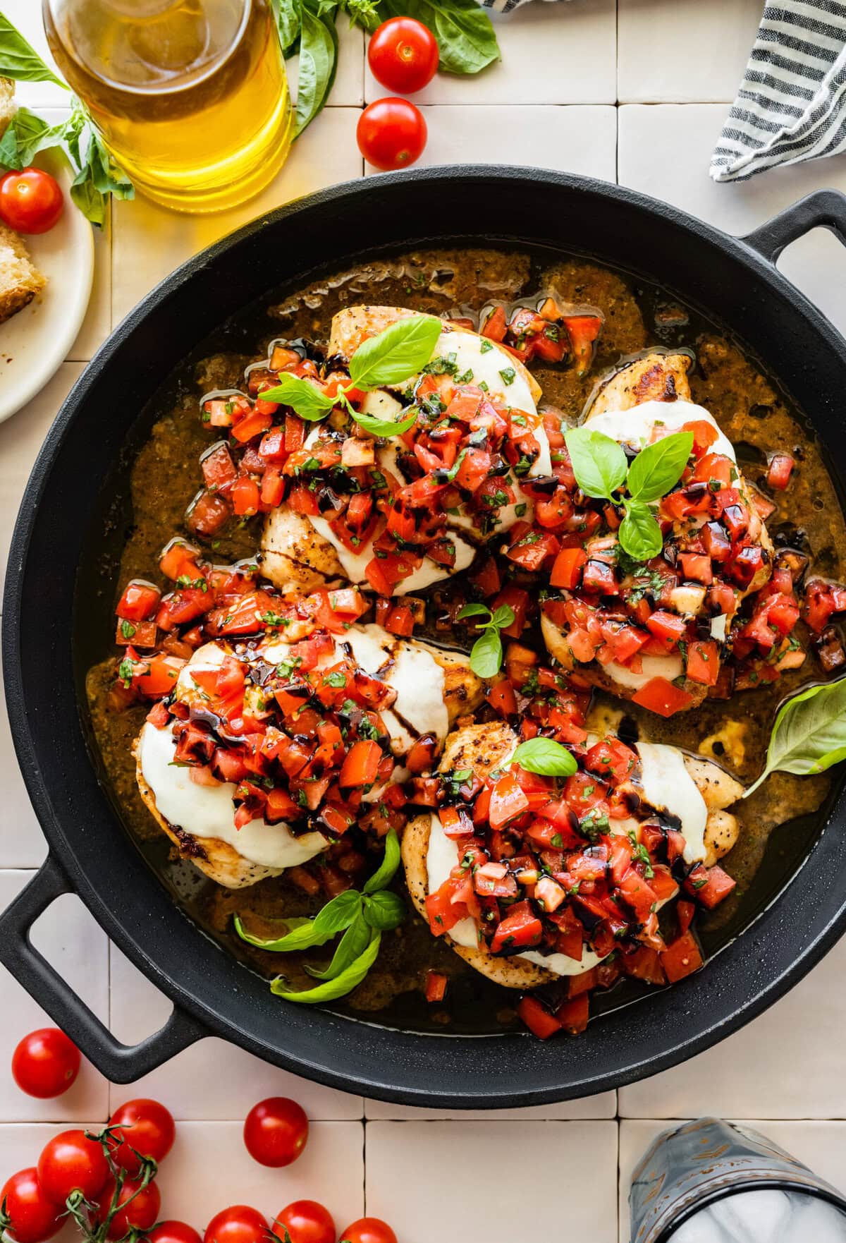 Chicken breasts with tomatoes and basil in a skillet