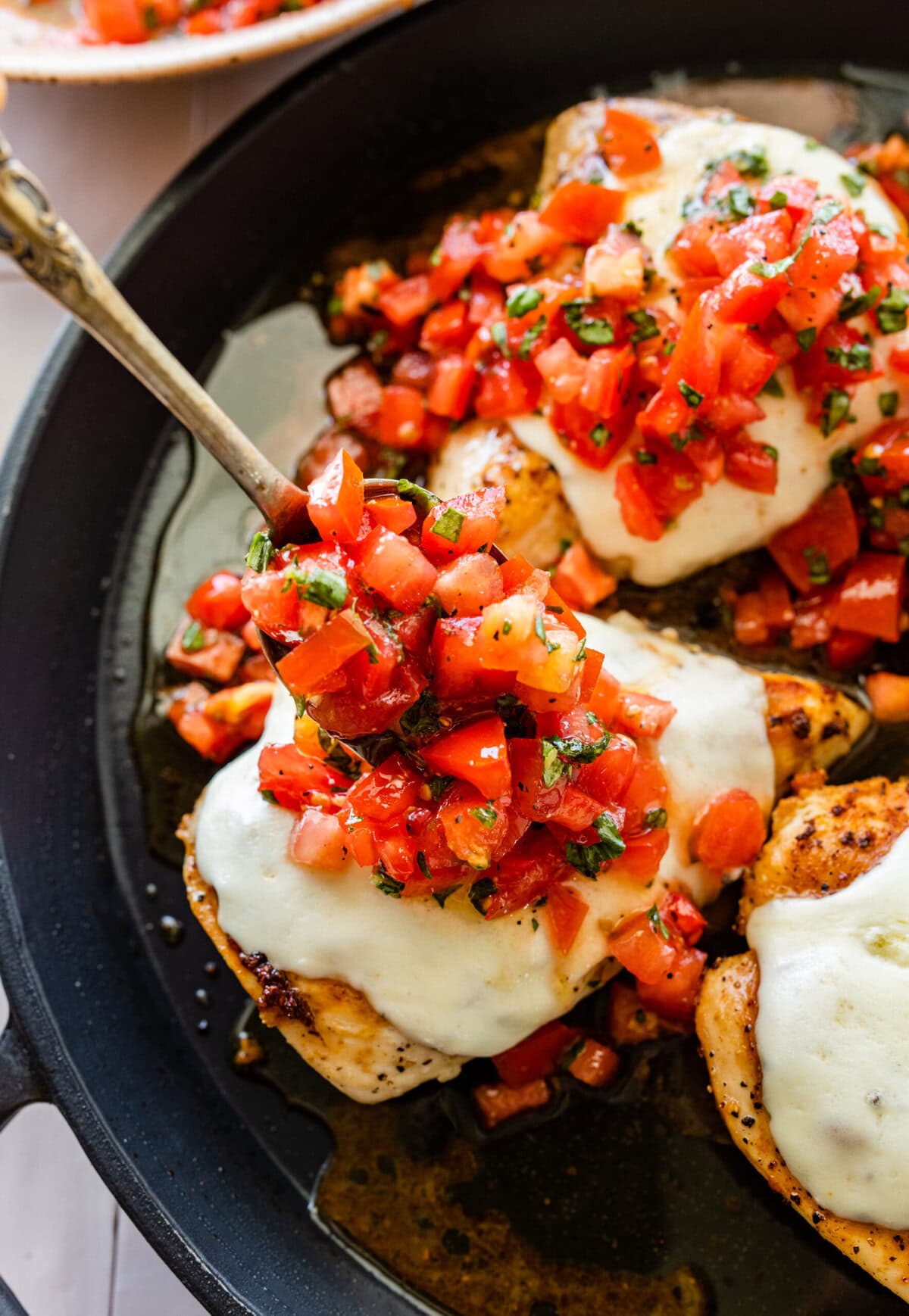 Chicken with tomato sauce and cheese in a skillet.
