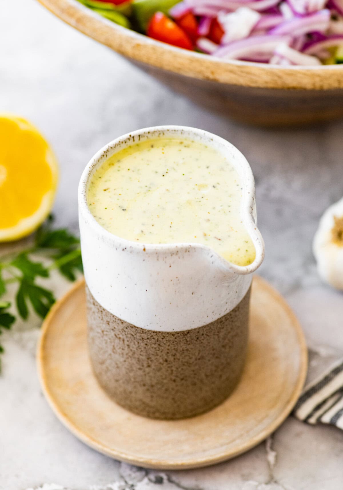 A bowl of creamy Italian dressing with a spoon.
