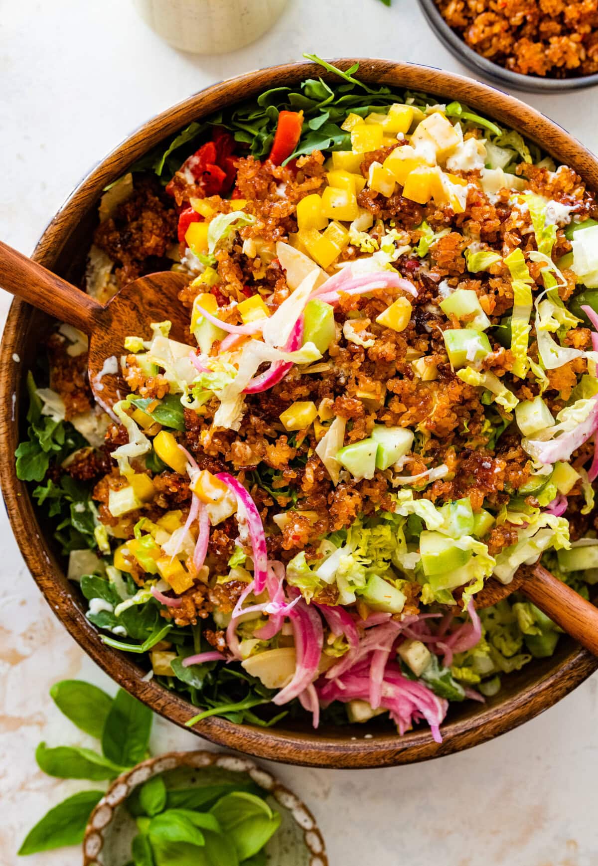 A bowl of salad with meat, vegetables and cheese