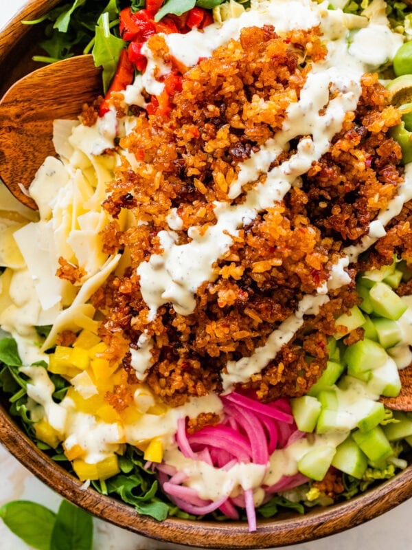 A bowl filled with crispy rice salad and dressing.