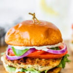 A chicken burger with lettuce, tomato, onion, cheese. and garlic lemon aioli.