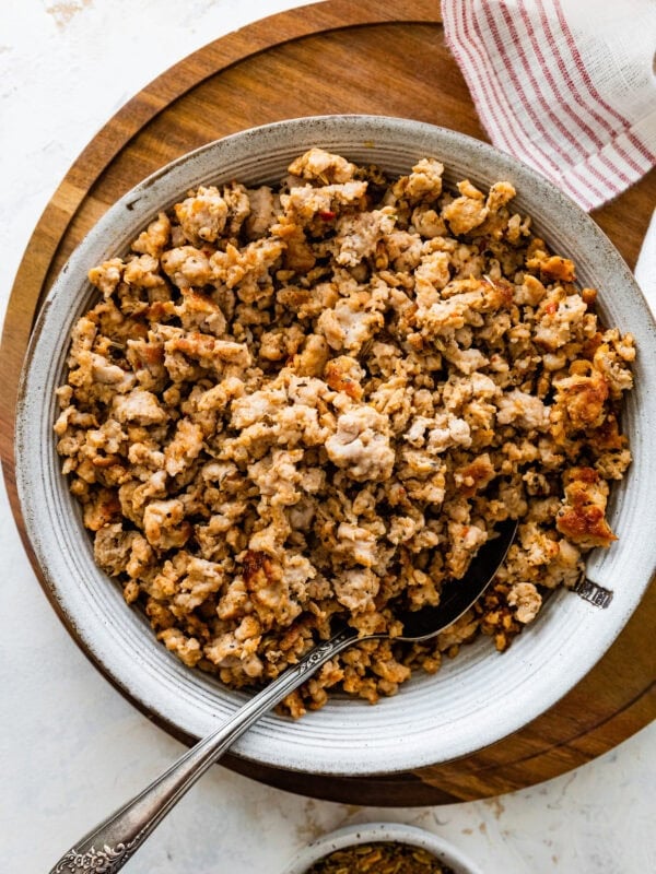 homemade Italian sausage cooked and crispy in a bowl with a spoon.