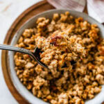 homemade Italian sausage cooked and crispy in a bowl with a spoon.
