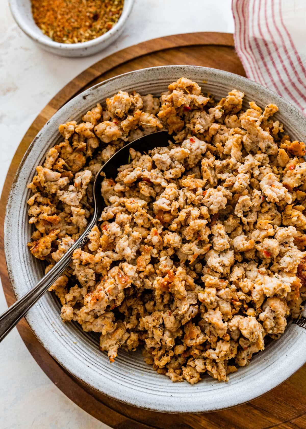 homemade Italian sausage cooked and crispy in a bowl with a spoon. 