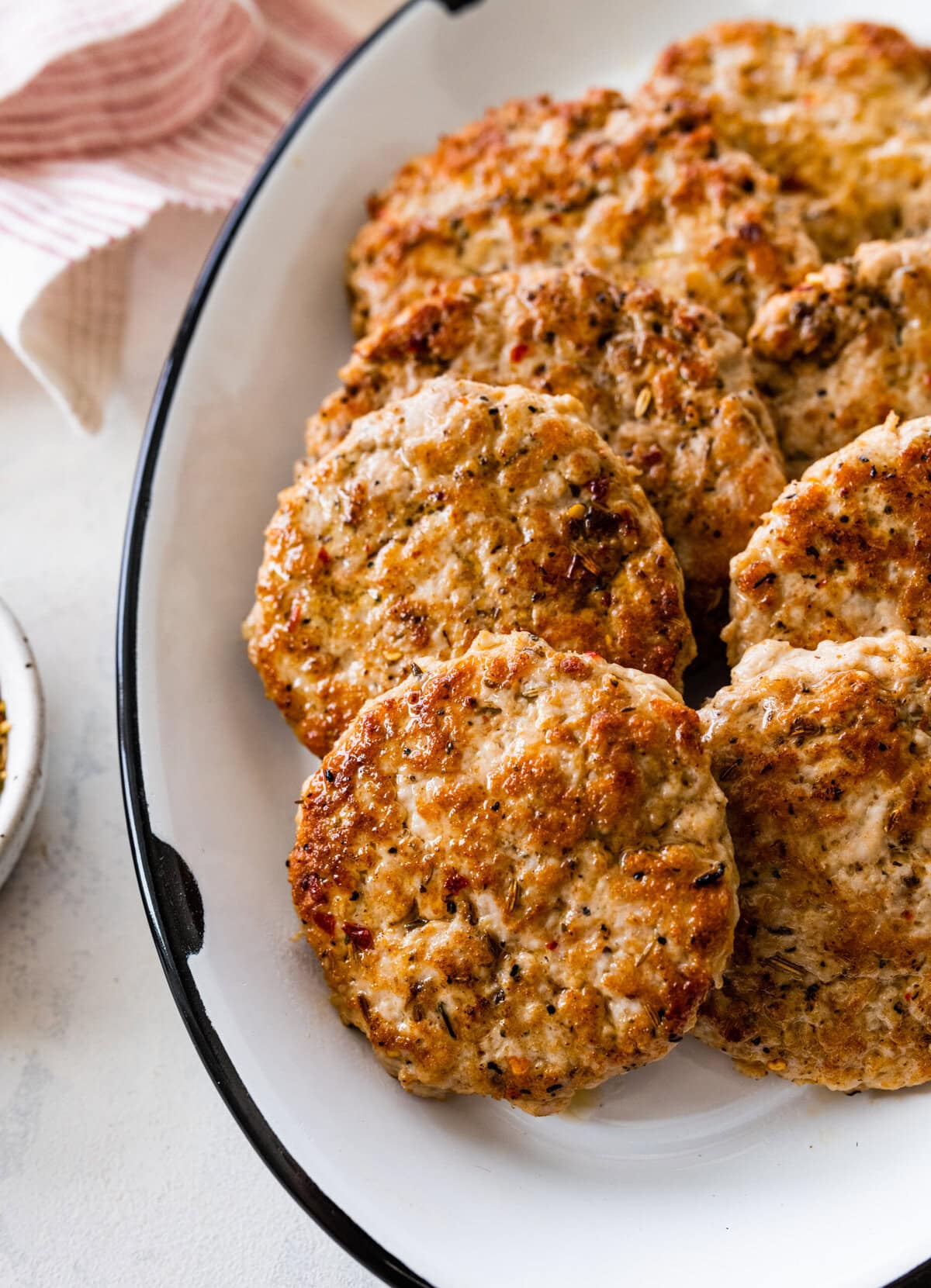 cooked homemade Italian sausage patties on a white plate.