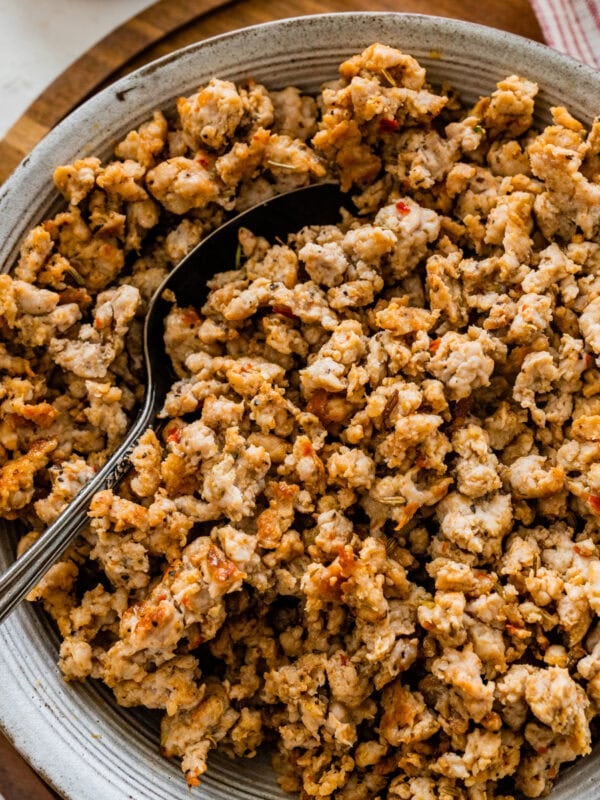 homemade Italian sausage cooked and crispy in a bowl with a spoon.