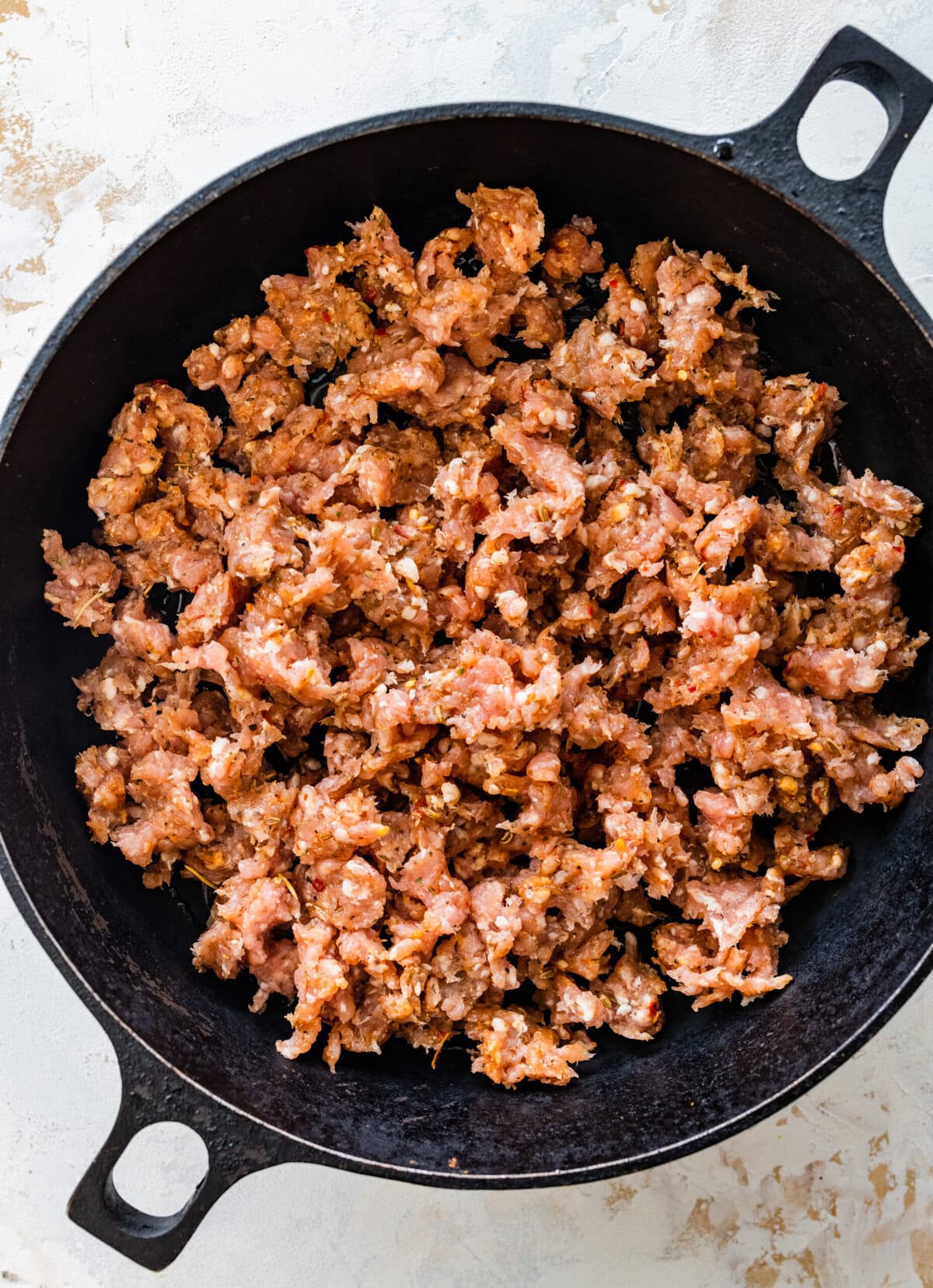 add homemade Italian sausage to a cast iron pan and cook.