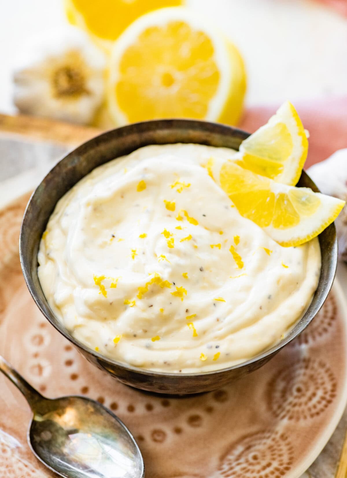 Lemon garlic aioli dip in a bowl with lemon slices.